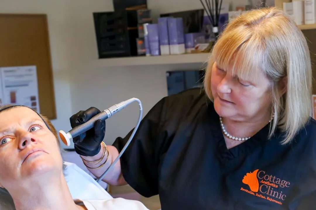 An aesthetic nurse carrying out a treatment on a client at Cottage Aesthetics Clinic